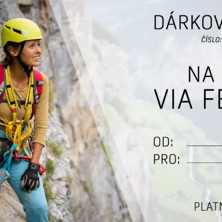 Dárkový poukaz na kurz Via Ferrata zobrazuje usměvavou ženu v horolezecké výstroji na skalnatém úbočí hory s připevněným jištěním. Poukaz obsahuje pole pro příjemce a datum a kontaktní údaje. Platí do 31. 12. 2024.